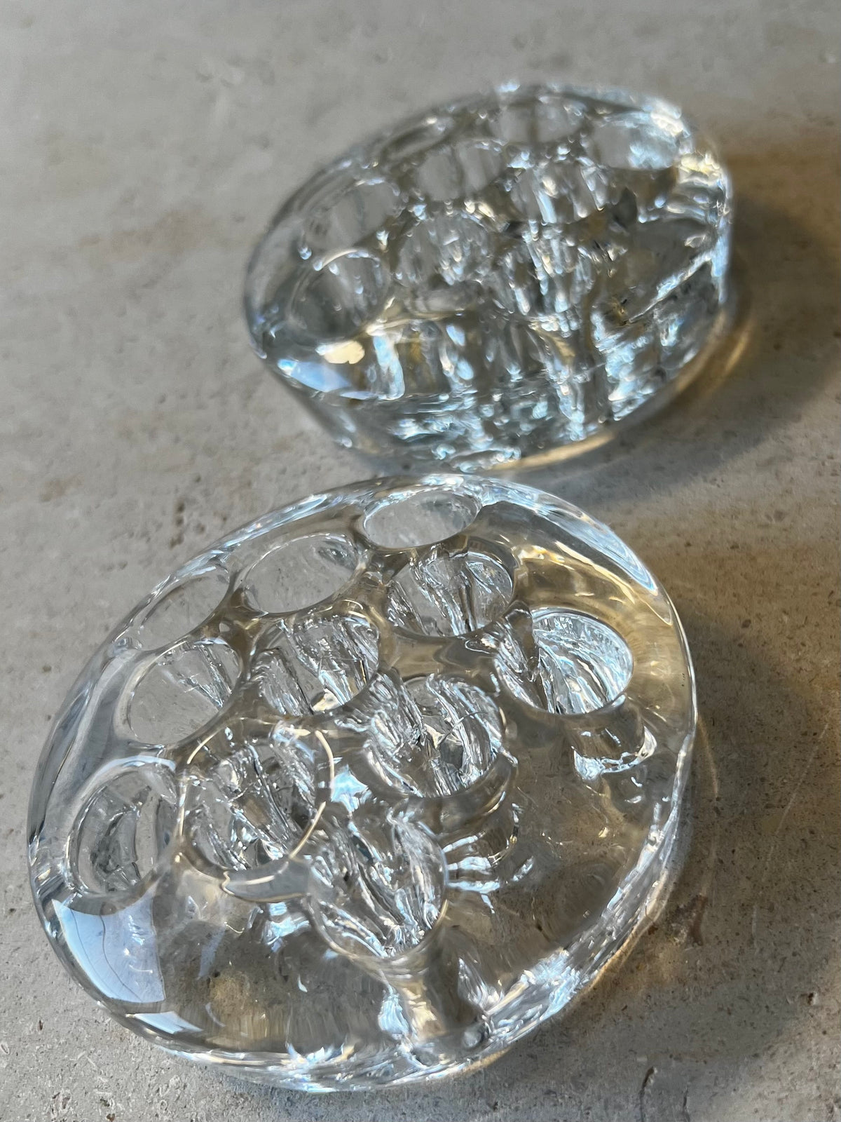 Two small round clear pressed glass flower frogs, thick base, molded stem holes