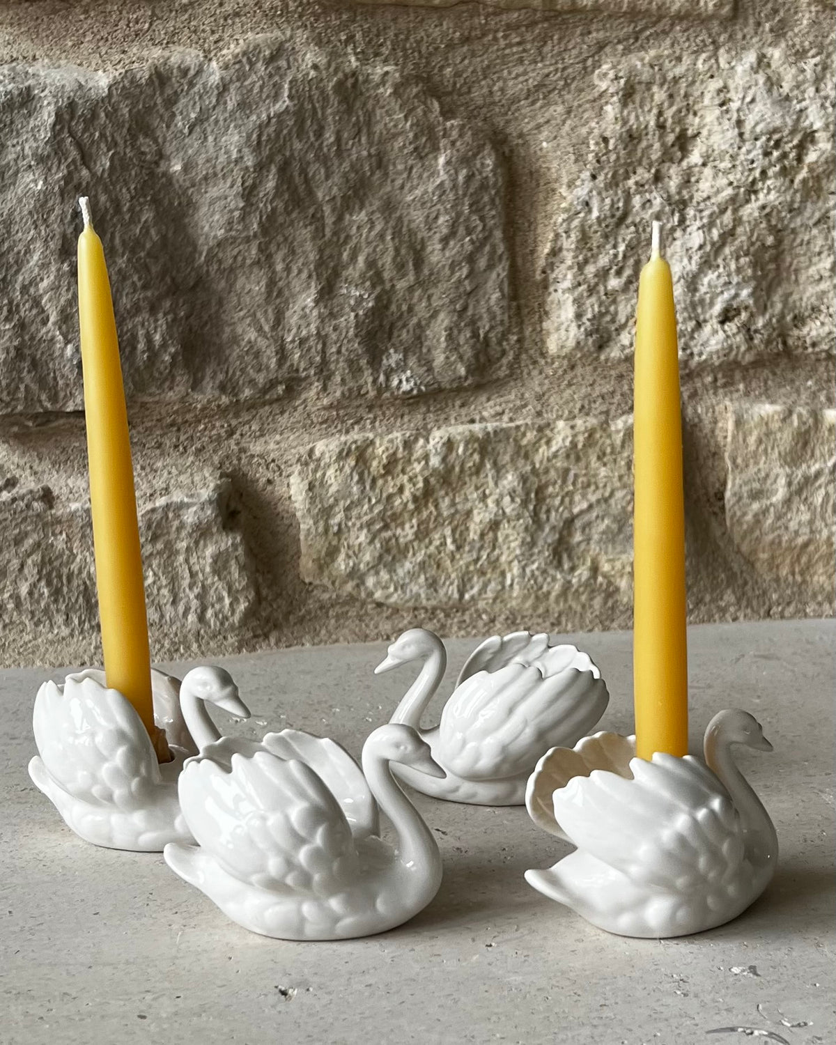 Goebel West Germany white porcelain swan taper holders, set of four, two holding yellow beeswax tapers