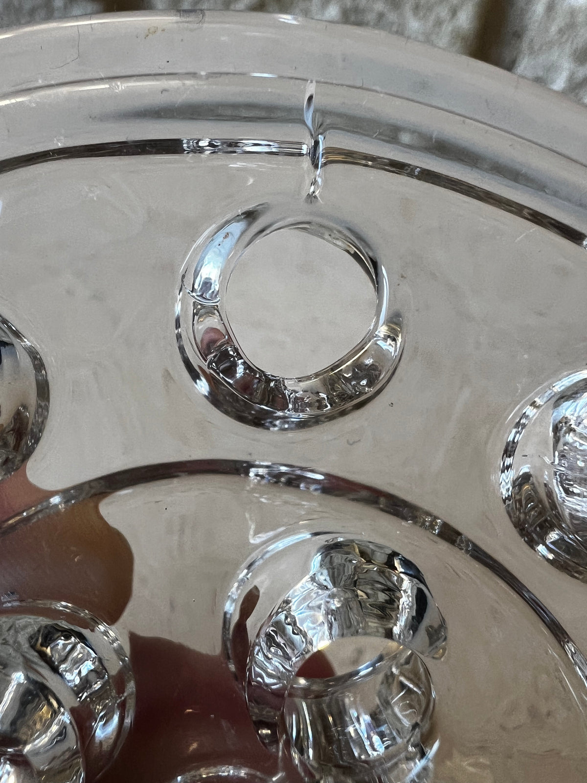 Close-up of clear pressed glass flower frog stem holes, molded rings, raised center