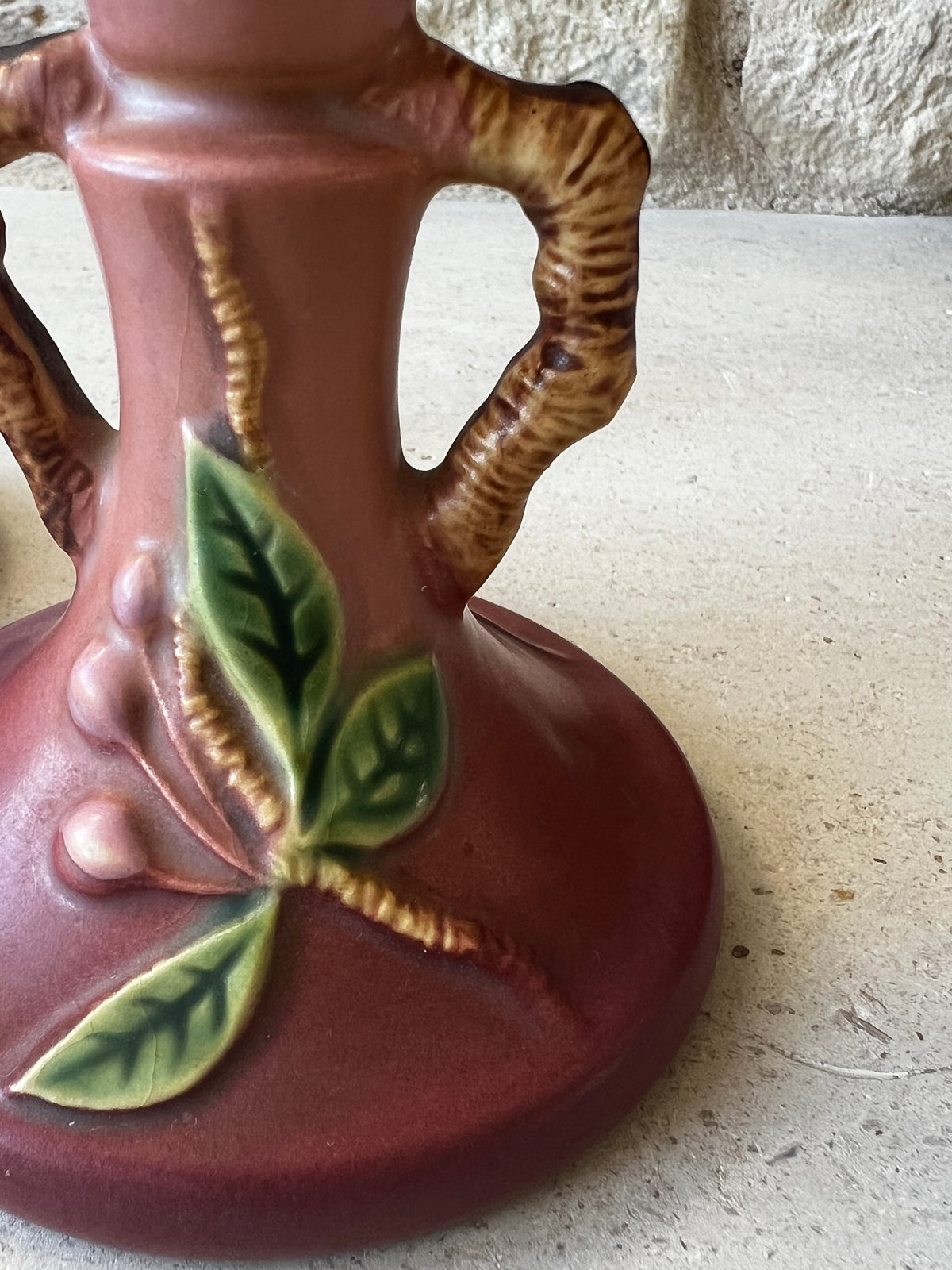 Close view of Apple Blossom leaves and branch-form handle on Roseville pottery candlestick