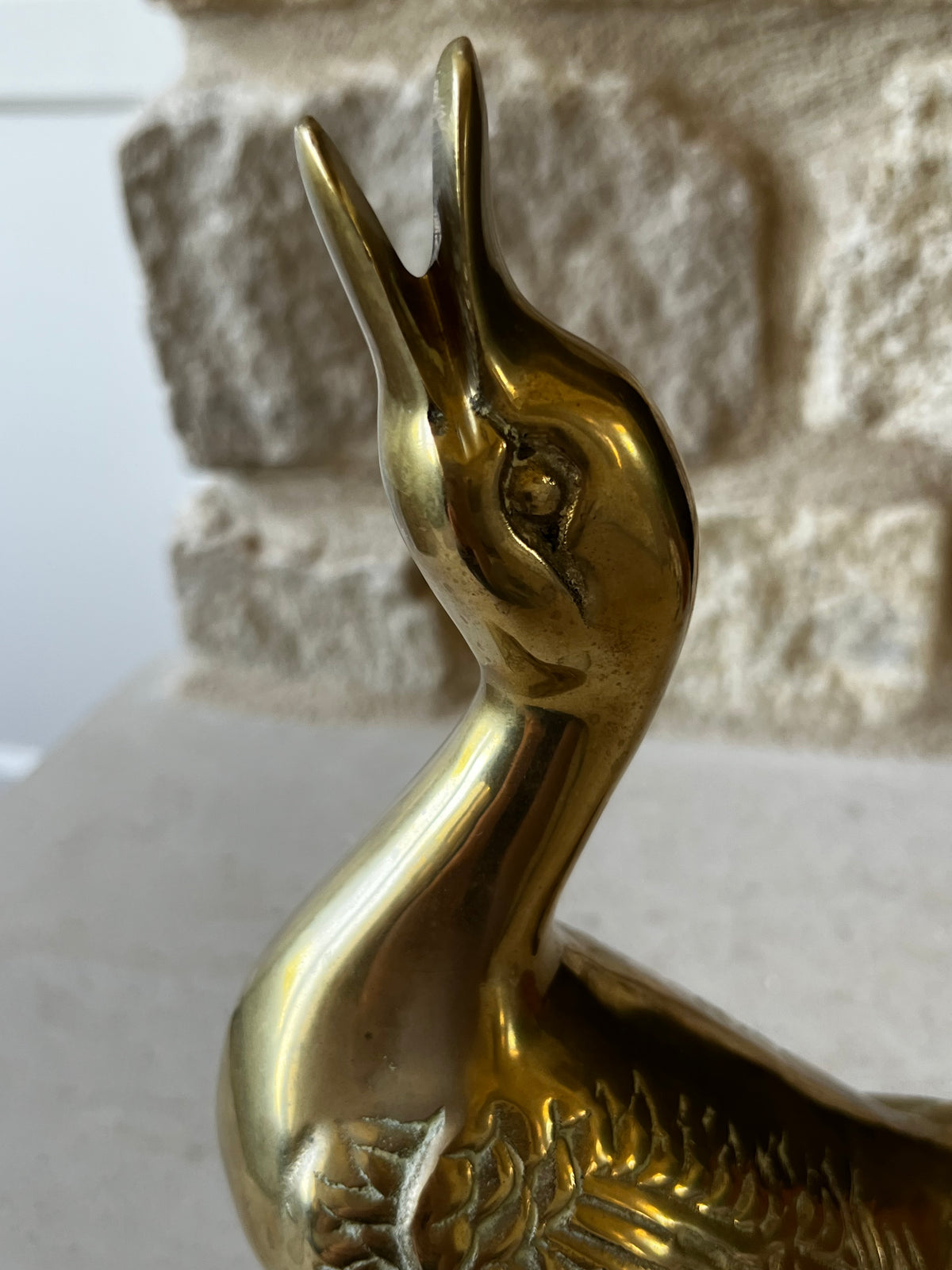 Close view of vintage brass goose head, open beak and curved neck
