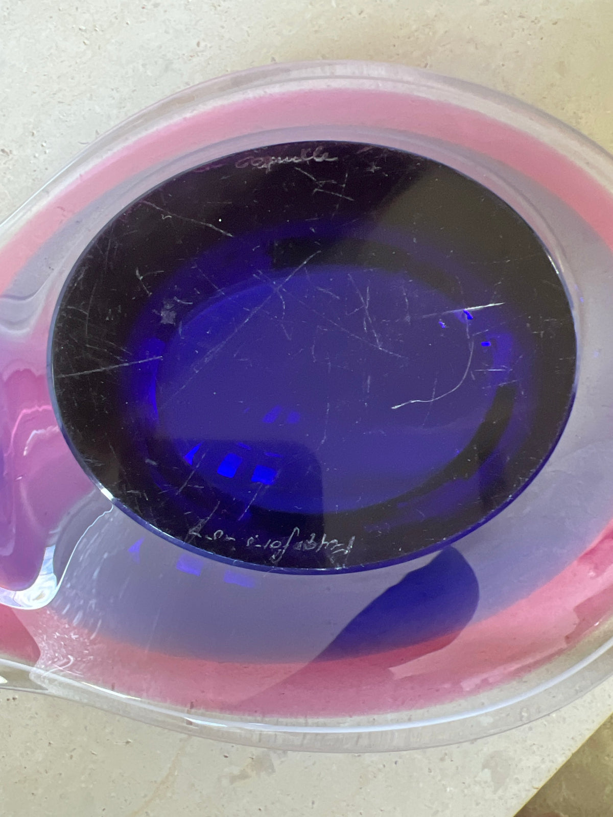 Underside of Flygsfors art glass bowl showing circular cobalt blue base with normal shelf ware from an item of its age. 