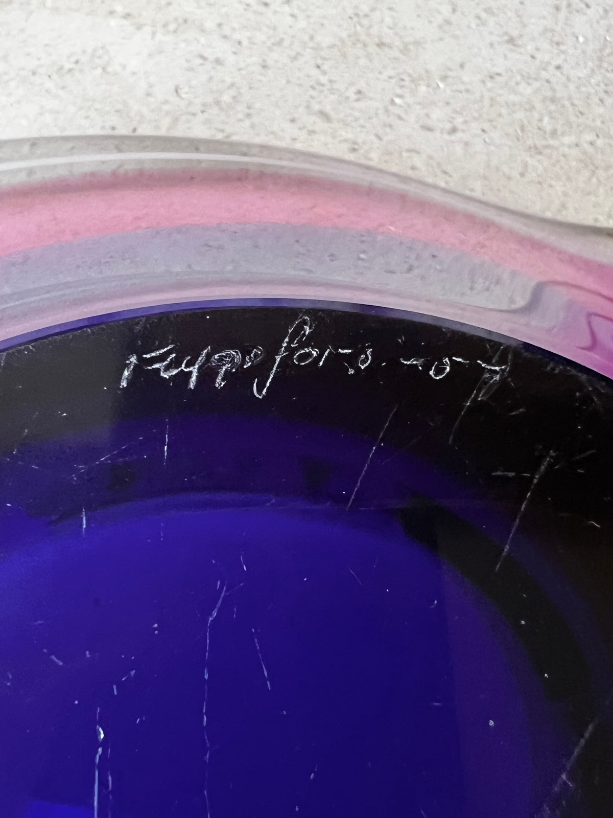 Close-up of engraved Flysfors - 57 signature on underside of a vintage glass bowl. 