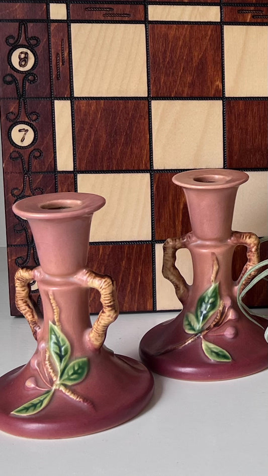 Pair of Roseville Apple Blossom candlesticks displayed by a wooden game board