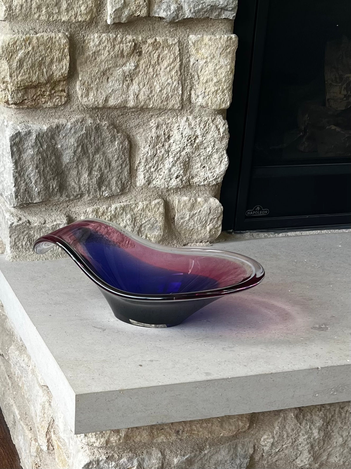 Flygsfors bowl displayed on limestone hearth, showing its elongated shape. 