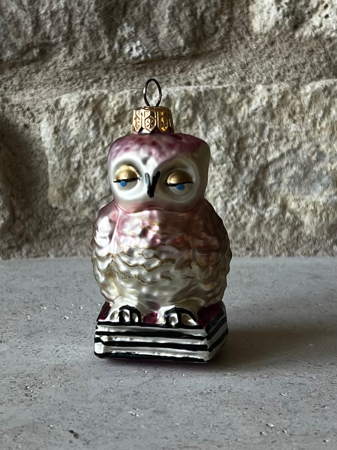 Polish blown glass owl ornament, pink and gold, painted eyes, perched on stacked books